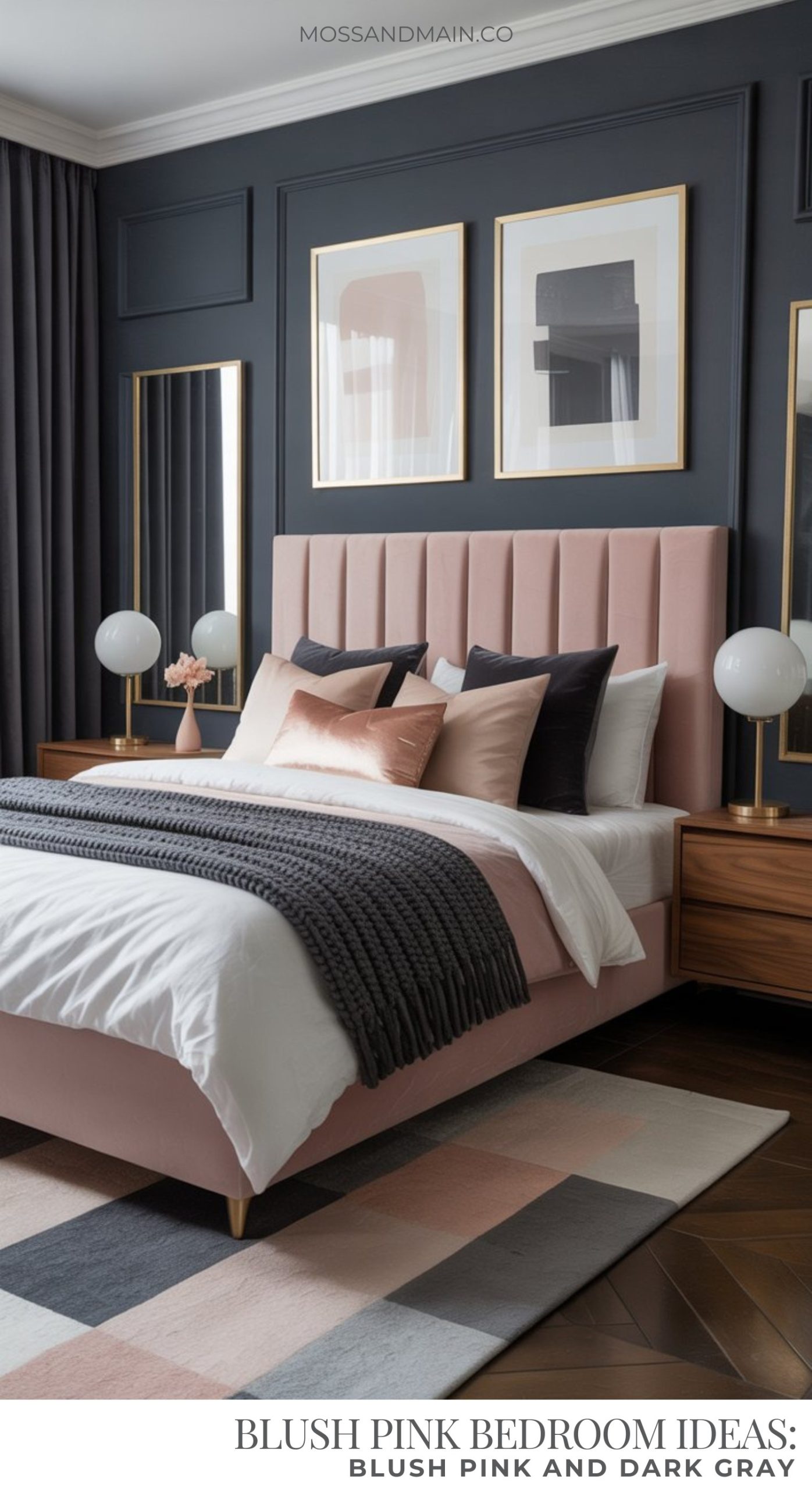 A modern blush pink bedroom features an upholstered bed with white bedding, pink and gray pillows, and a dark gray knitted throw. Wooden nightstands with globe lamps and framed art decorate the dark gray paneled wall.
