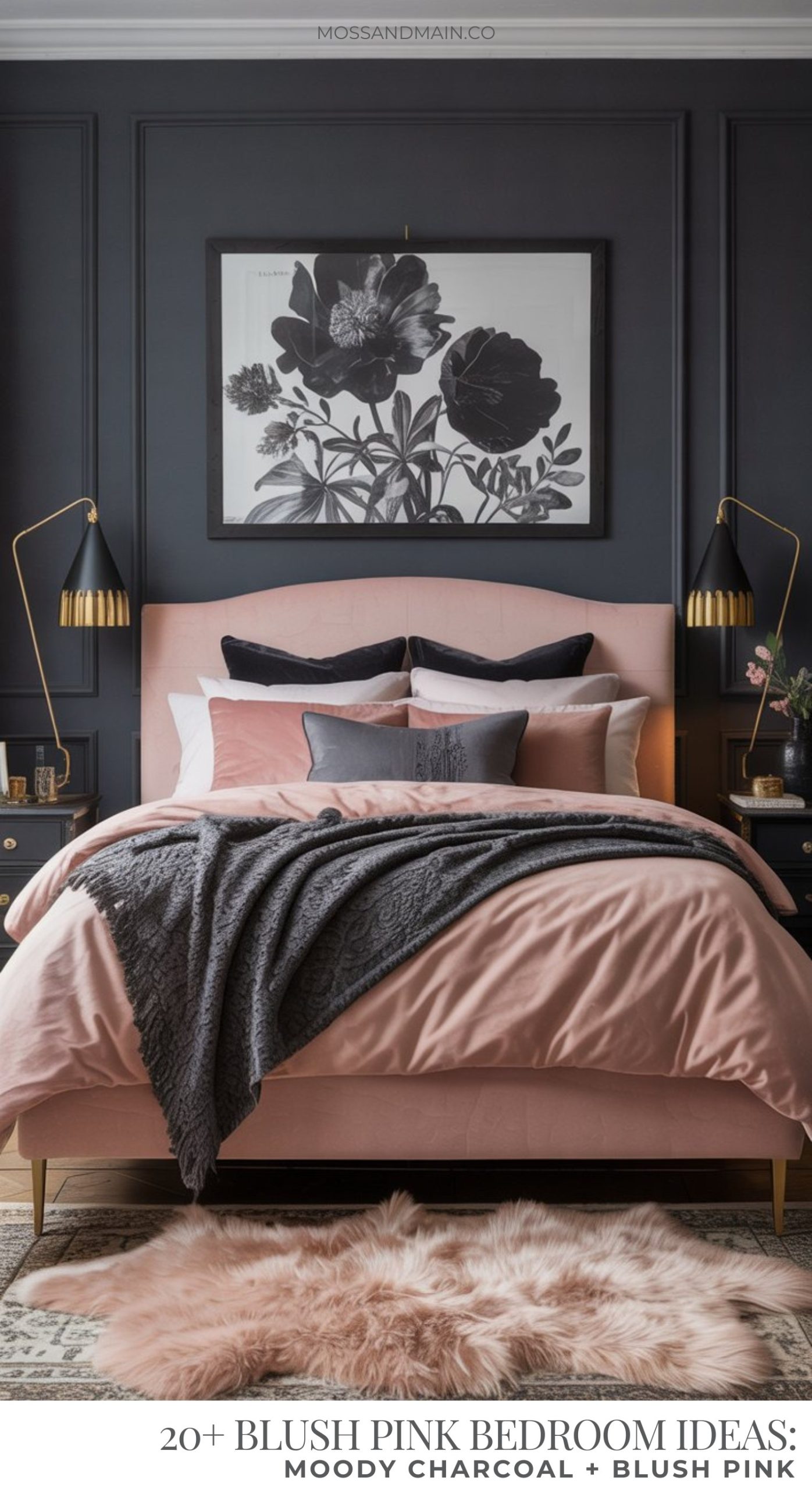 A stylish blush pink bedroom featuring a bed with layered pillows and a dark gray throw, set against a moody charcoal wall. A botanical artwork hangs above the bed, with modern lamps and nightstands on either side.