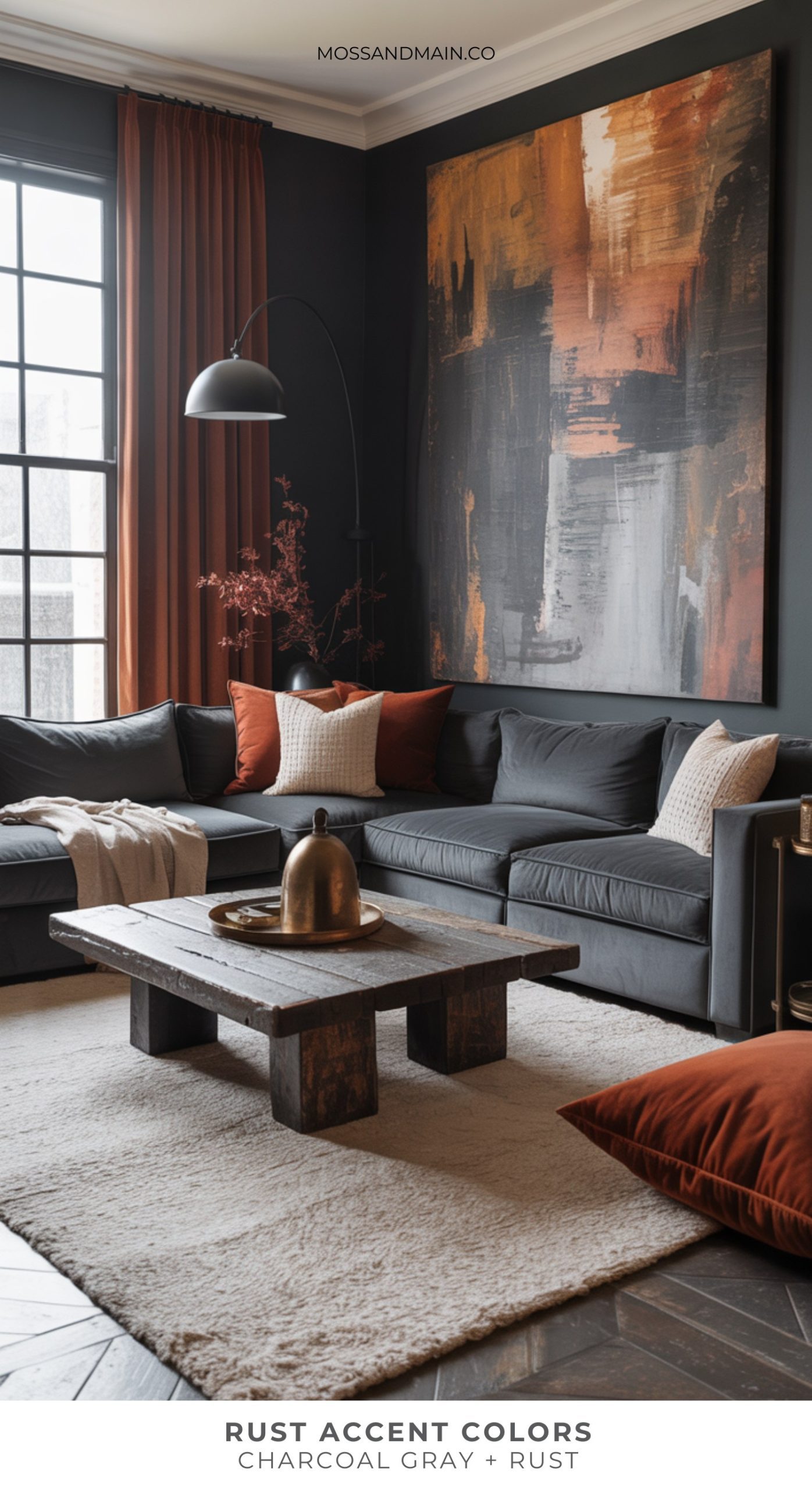A modern living room with a charcoal gray sectional sofa, rust-colored pillows, rust curtains, and a rustic wooden coffee table on a cream rug showcases trendy rust home decor. Text reads: Rust Accent Colors: Charcoal Gray + Rust.