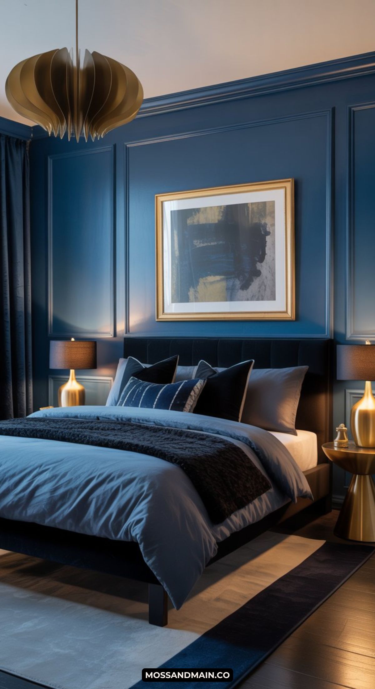 A stylish masquerade bedroom with dark blue walls, a modern bed with blue and gray bedding, two gold lamps on matching nightstands, a gold statement chandelier, and abstract wall art above the bed.