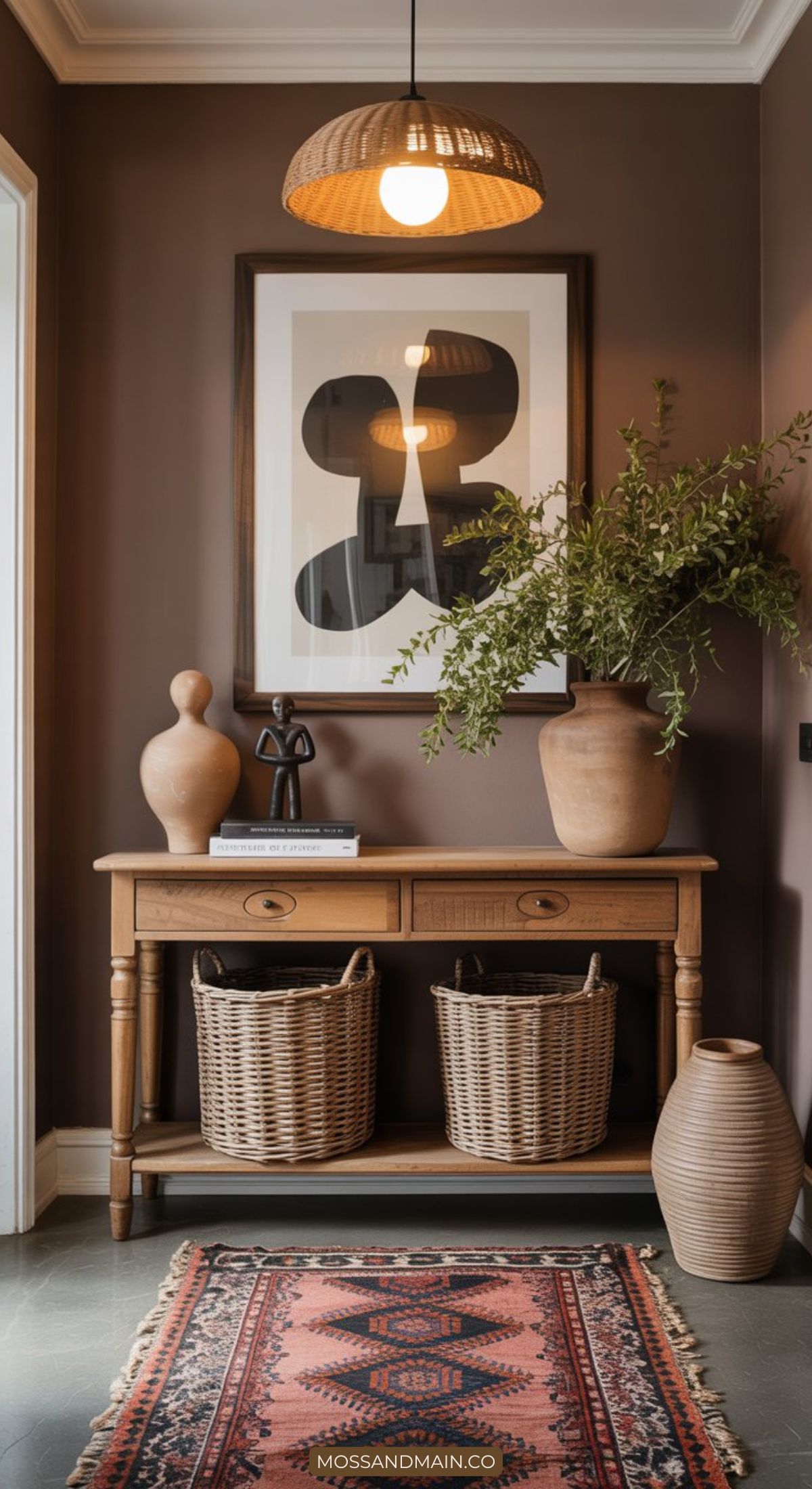 A wooden console table with two woven baskets underneath, topped with decorative vases and a plant, brings Afrohemian decor to life against a brown wall under a rattan pendant light—a perfect example of textured home style above a patterned rug.
