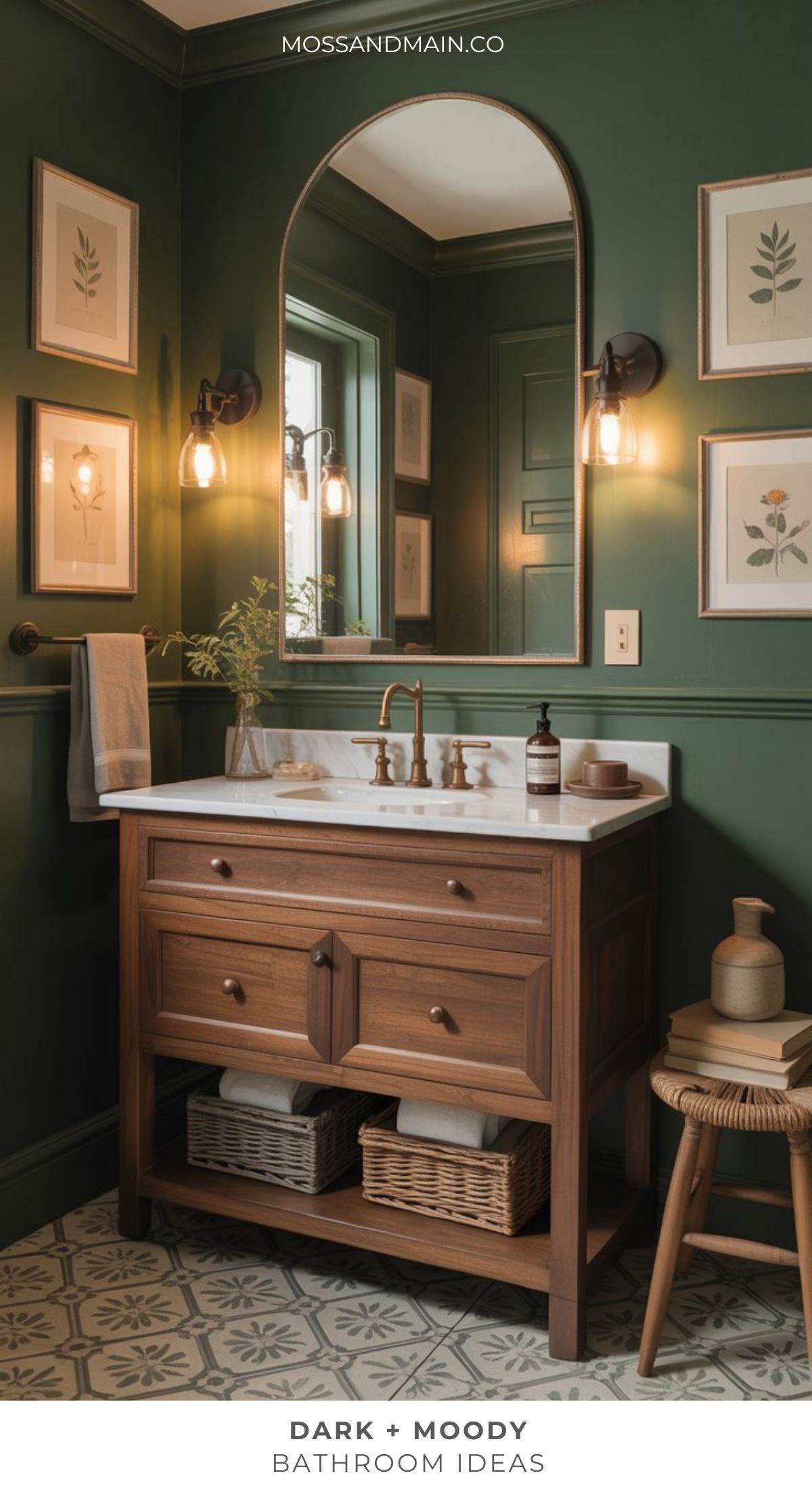 A stylish Dark Moody Bathroom with dark green walls, botanical wall art, a wooden vanity topped with marble, modern brass fixtures, warm lighting, and decorative floor tiles creates a cozy and dramatic ambiance.
