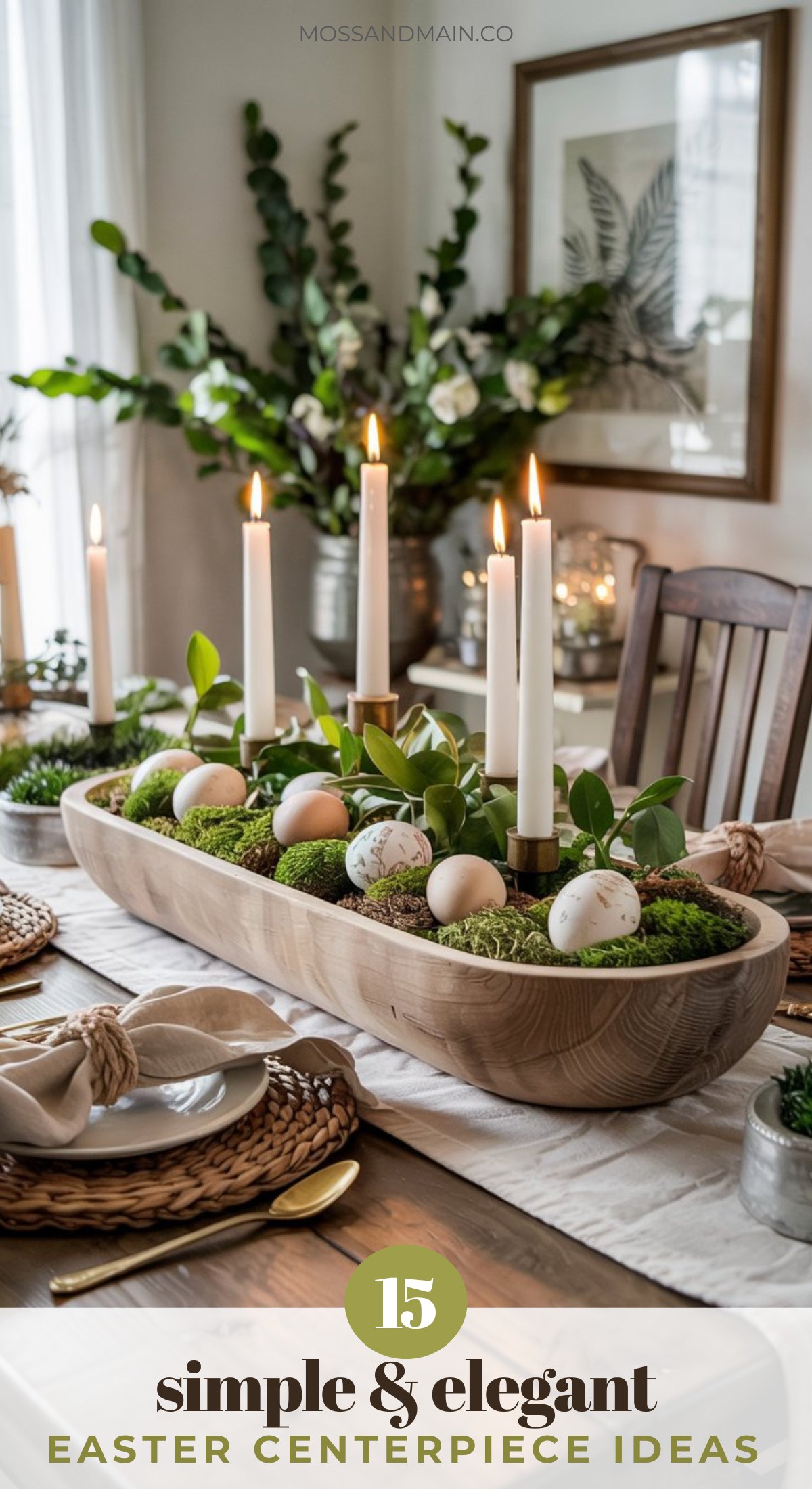 A wooden dining table set for Easter features a long wooden centerpiece filled with moss, greenery, and painted eggs—an elegant Easter centerpiece idea. White taper candles complete the cozy, natural, and sophisticated spring table decor.