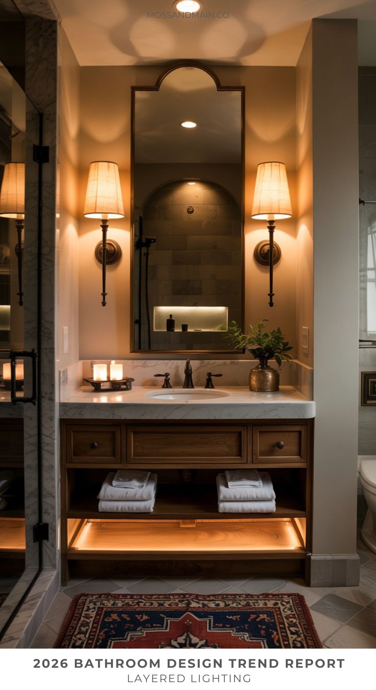 A stylish bathroom features a wooden vanity with towel shelves, a large mirror, and cozy layered lighting—perfect bathroom inspiration that blends modern yet classic decor in line with upcoming bathroom trends 2026.