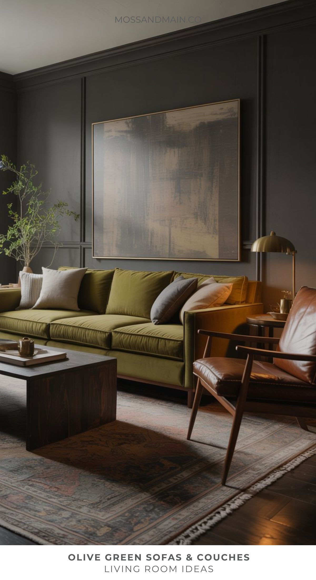 A modern living room features an olive green sofa, a brown armchair, a dark wooden coffee table, and a large abstract painting—perfect inspiration for those seeking fresh living room ideas from top designers.