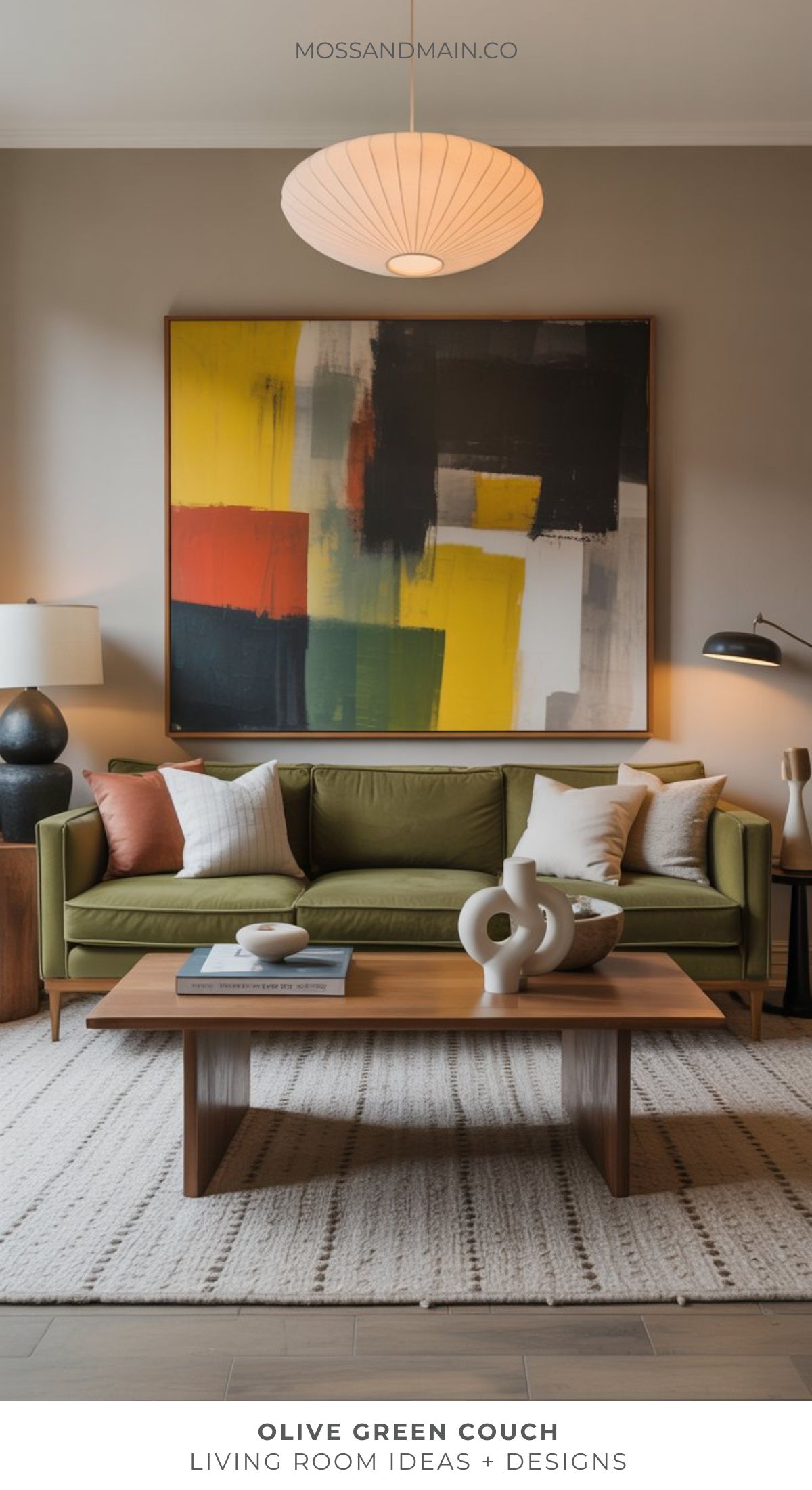 A modern living room with an olive green sofa, neutral pillows, wooden coffee table, large abstract colorful wall art, table lamps, and decor on a textured rug—an inspiring space for those seeking fresh living room ideas from top designers.