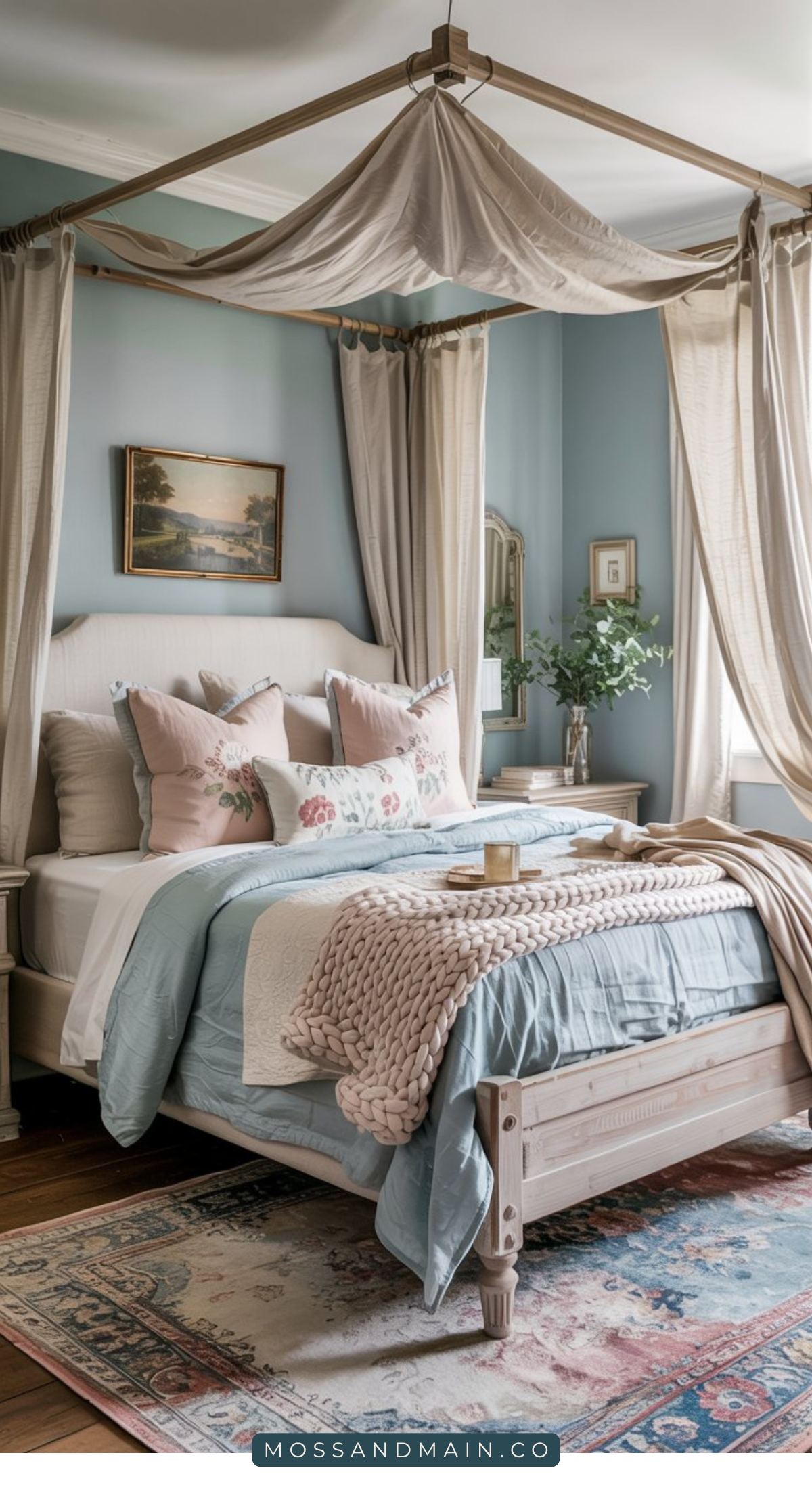 A cozy Blue Cottagecore Bedroom with a canopy bed, soft blue and cream bedding, floral pillows, a chunky knit blanket, vintage rug, and natural light streaming through curtains. A small nightstand holds a vase with greenery.