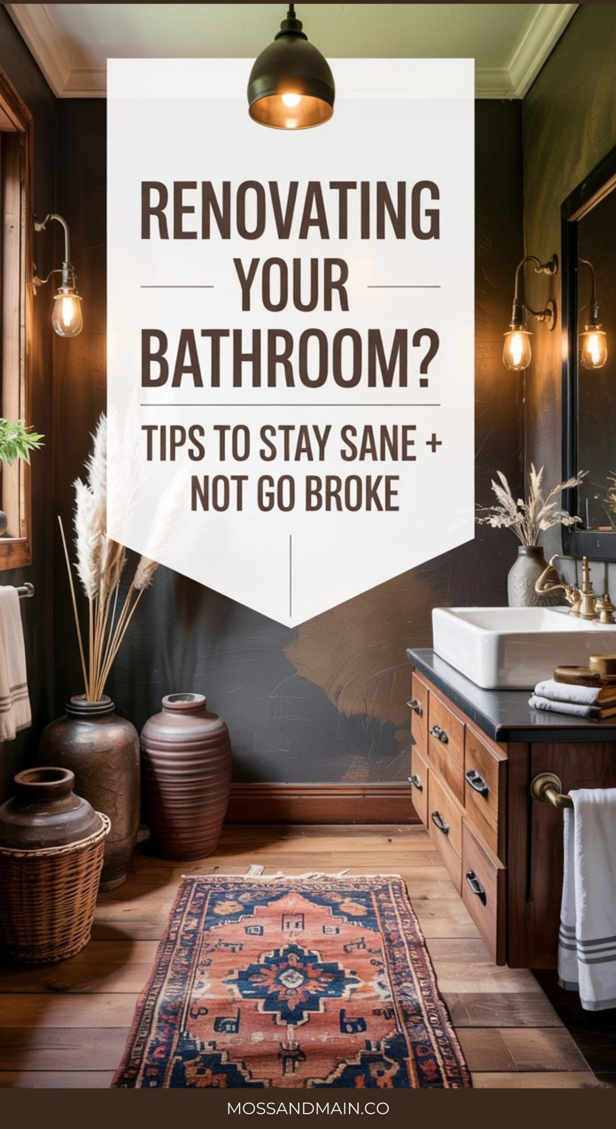 A stylish bathroom with dark walls, a wooden vanity, decorative vases, a patterned rug, and soft lighting. Text overlay reads: “Renovating your bathroom? Tips to stay sane + manage your bathroom remodel cost. mossandmain.co.”.
