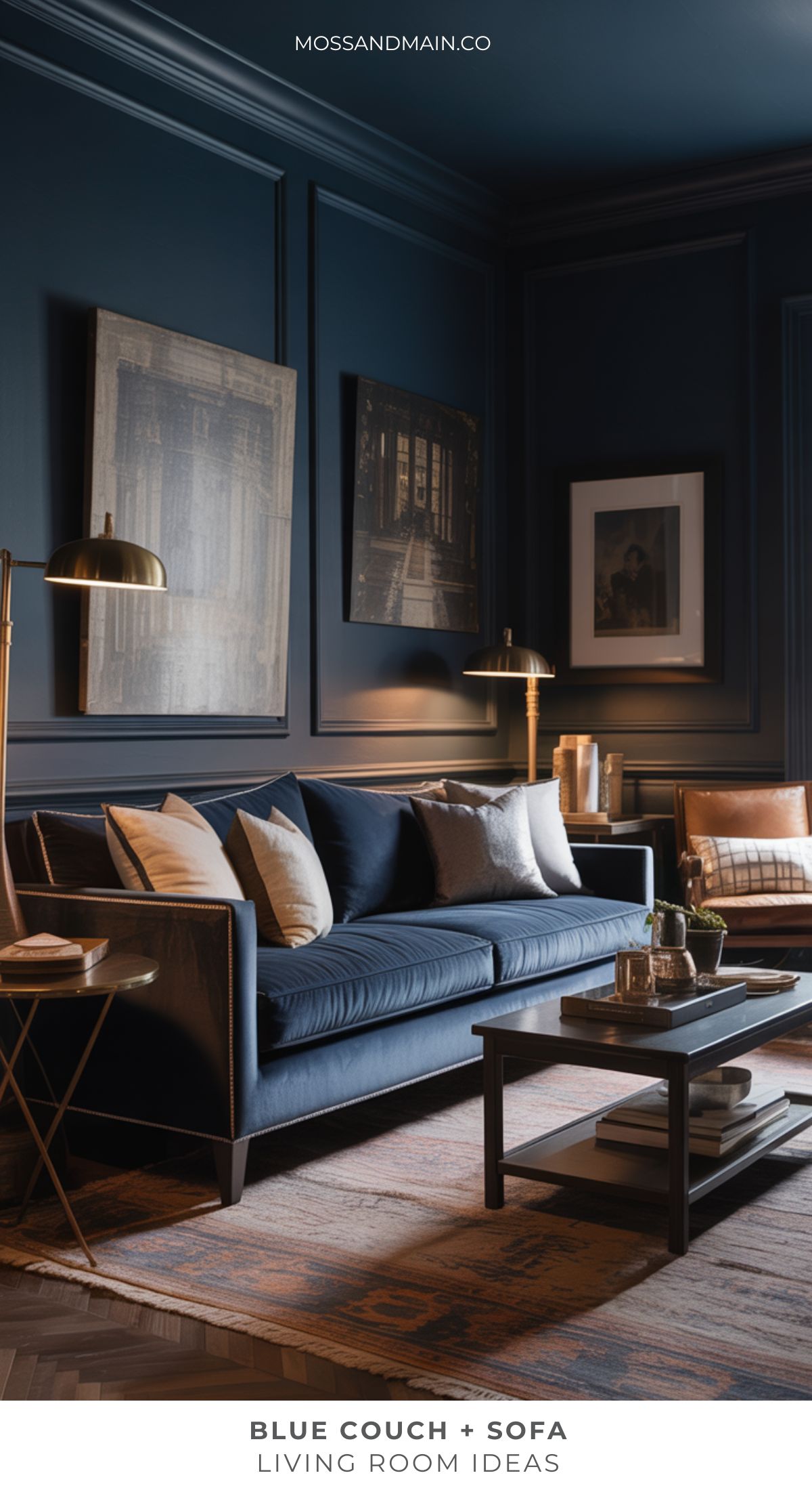 A stylish blue couch living room with dark blue walls, a sofa with beige and white pillows, a modern coffee table, brass floor lamps, framed art, and a tan accent chair. The space exudes cozy sophistication.