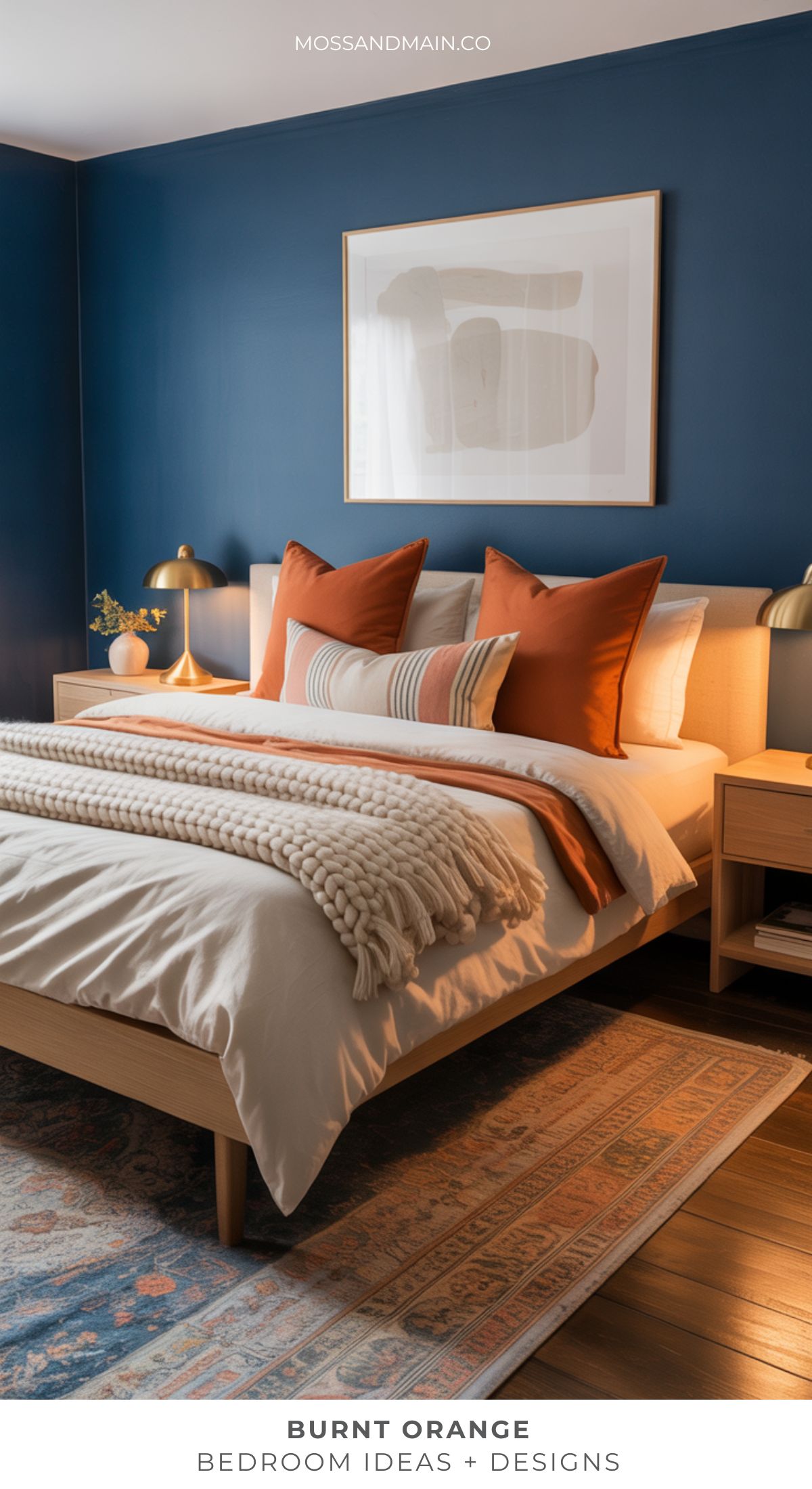 A cozy burnt orange bedroom with a wooden bed, striped pillows, a cream knit throw, blue accent wall, bedside lamps, framed abstract art, and a patterned rug on wooden flooring—perfect for those seeking warm bedroom ideas or beige alternatives.