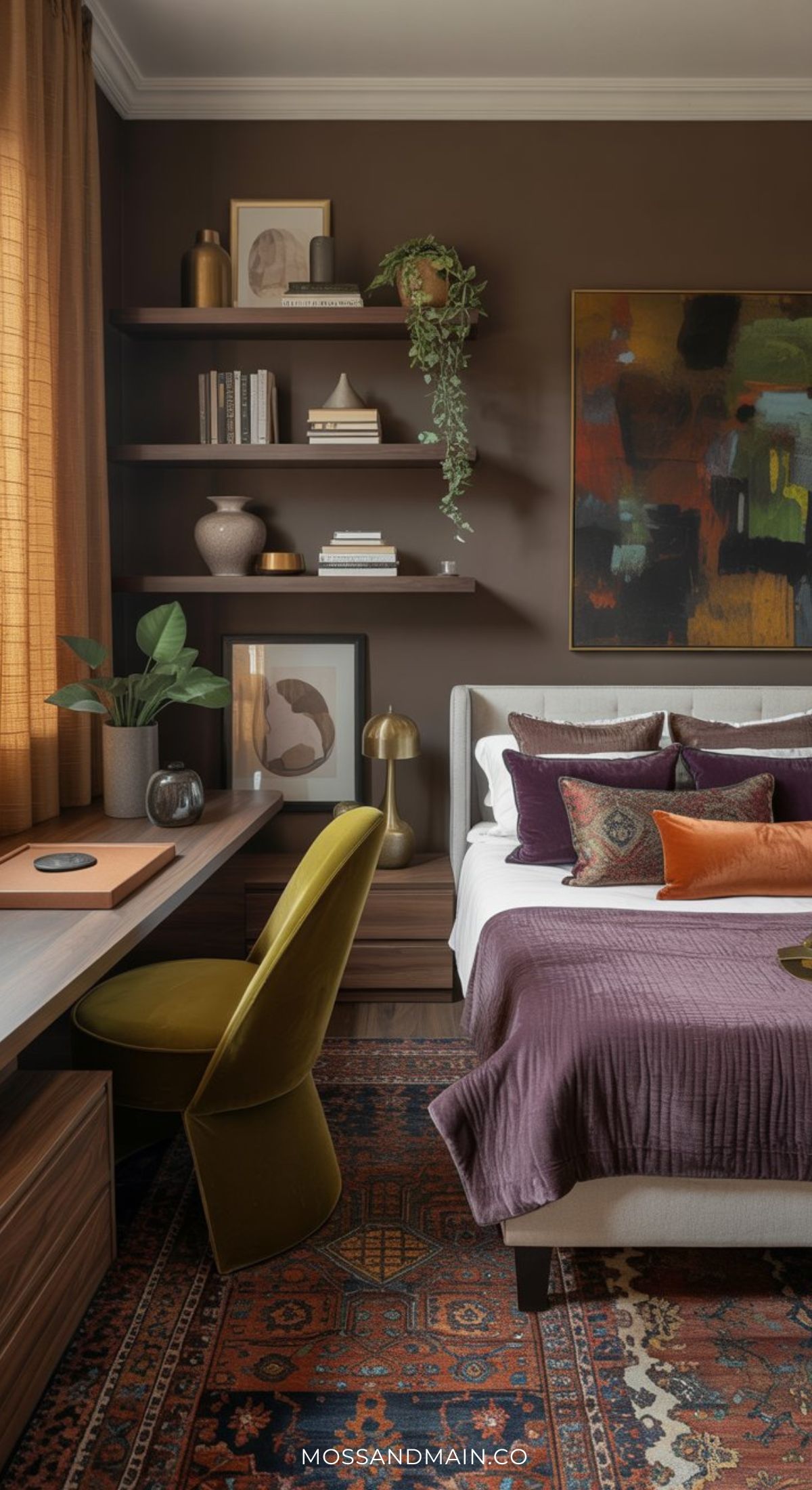 A cozy bedroom with brown walls, shelves with books and decor, a large abstract painting, purple and rust bedding, a patterned rug, and a desk with a green chair highlights 2026 Home Office Trends for stylish yet functional spaces.