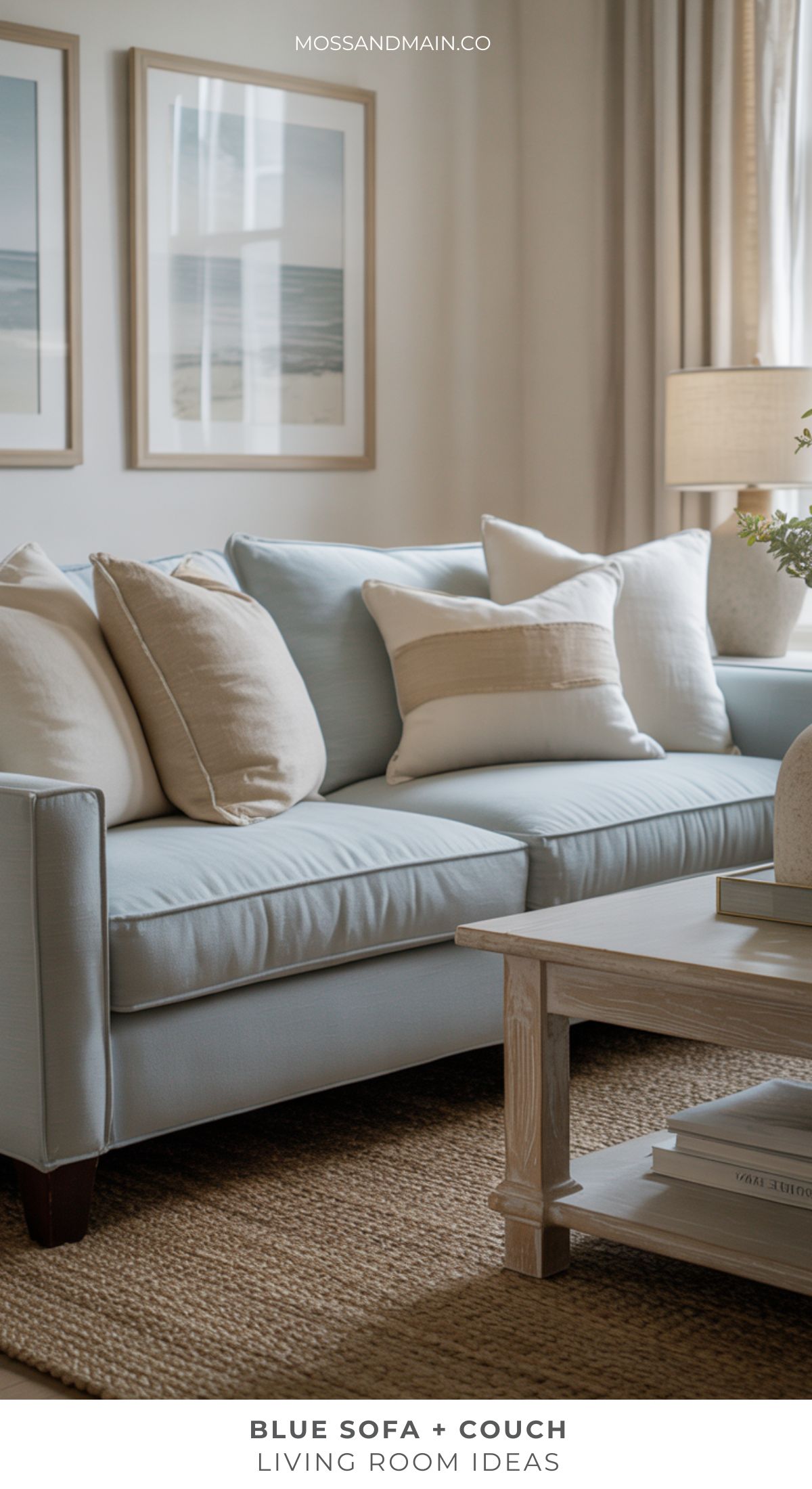 A light blue couch with cream and beige throw pillows sits on a woven rug in a cozy living room. A wooden coffee table is in front, and framed art adds inspiration for fresh living room ideas in this calm, inviting space.