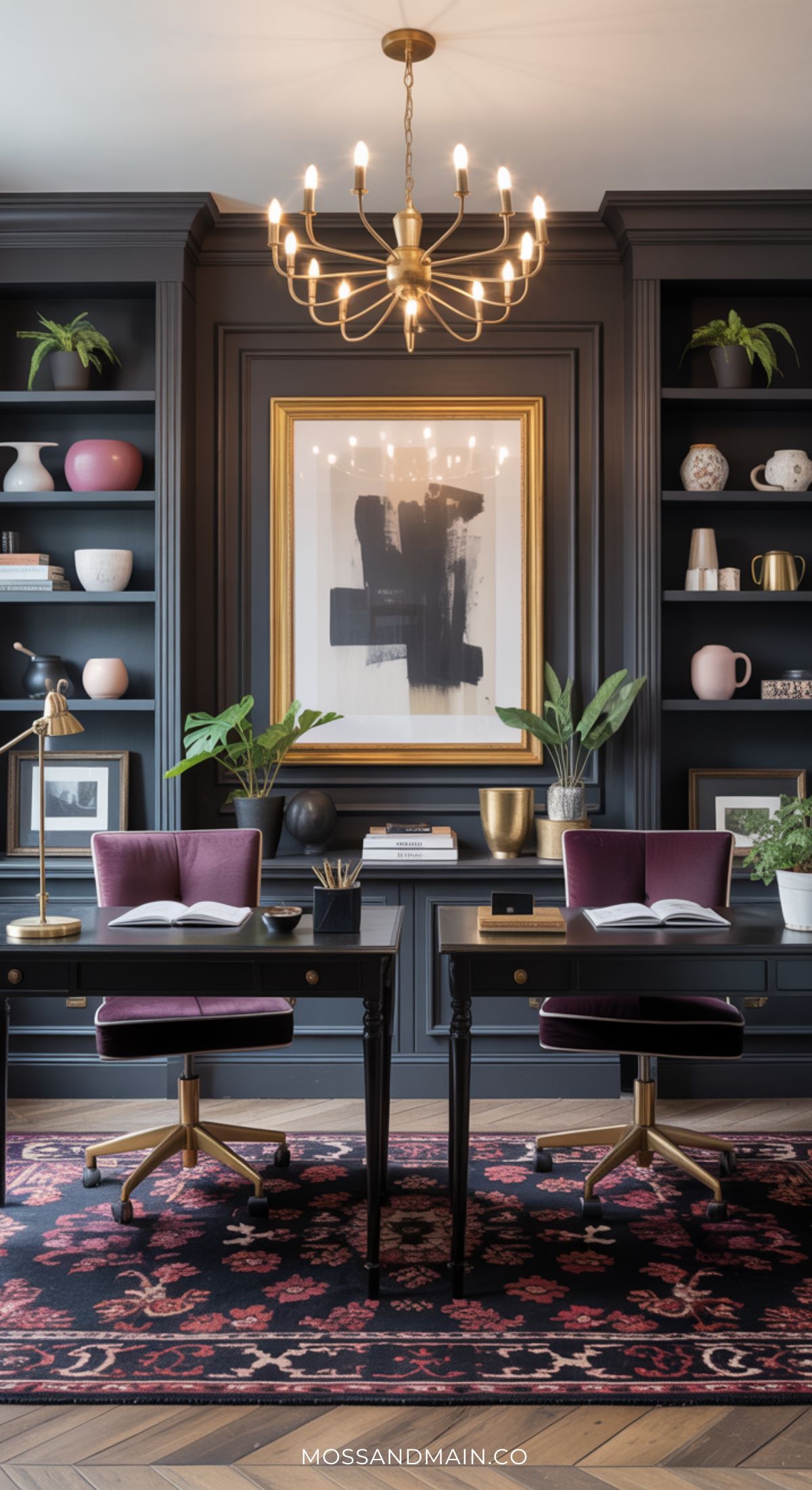 A moody home office for two features black desks with purple velvet chairs, a gold chandelier, dark built-in bookshelves adorned with decor and plants, a large abstract painting, and a patterned rug on wooden floors.