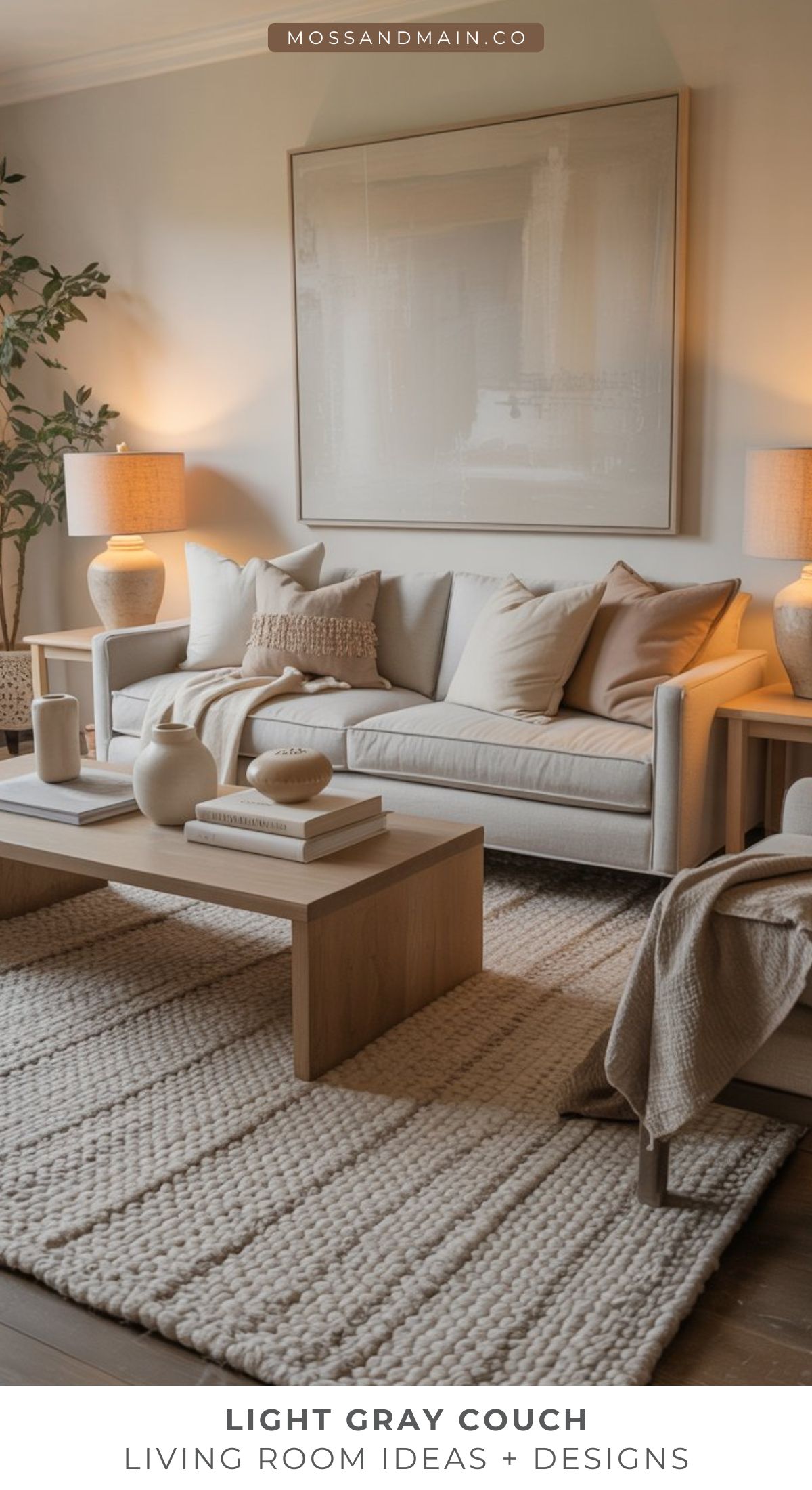 A modern living room with a light gray couch, neutral decor, wooden coffee table, textured rug, large framed artwork, and soft lighting from two table lamps—perfect for those seeking cozy living room ideas.