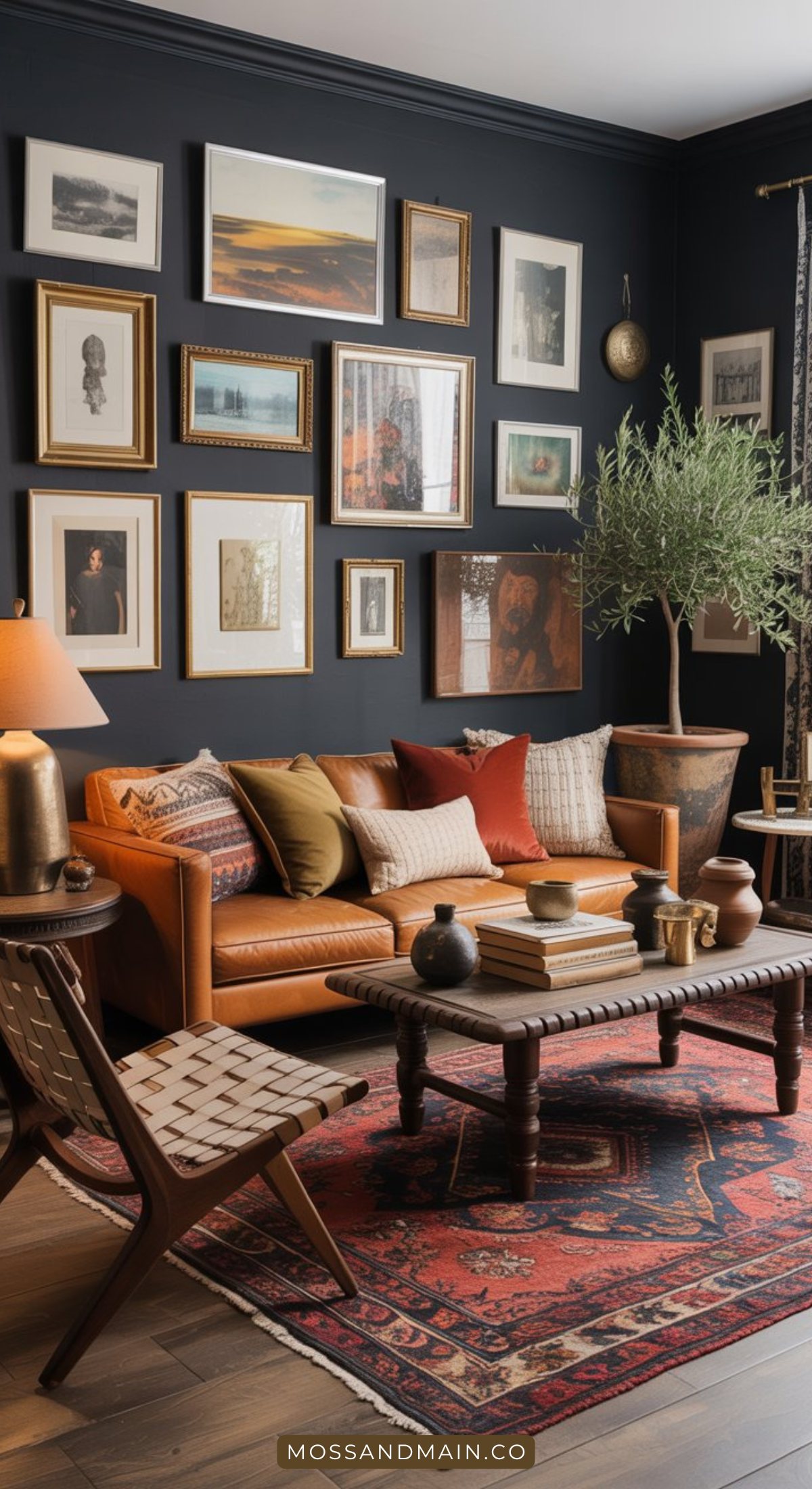 A cozy living room showcases dark living room ideas with a leather sofa, colorful cushions, a patterned rug, and warm lighting. The moody living room features a gallery wall of framed art and photographs, creating an inviting atmosphere.