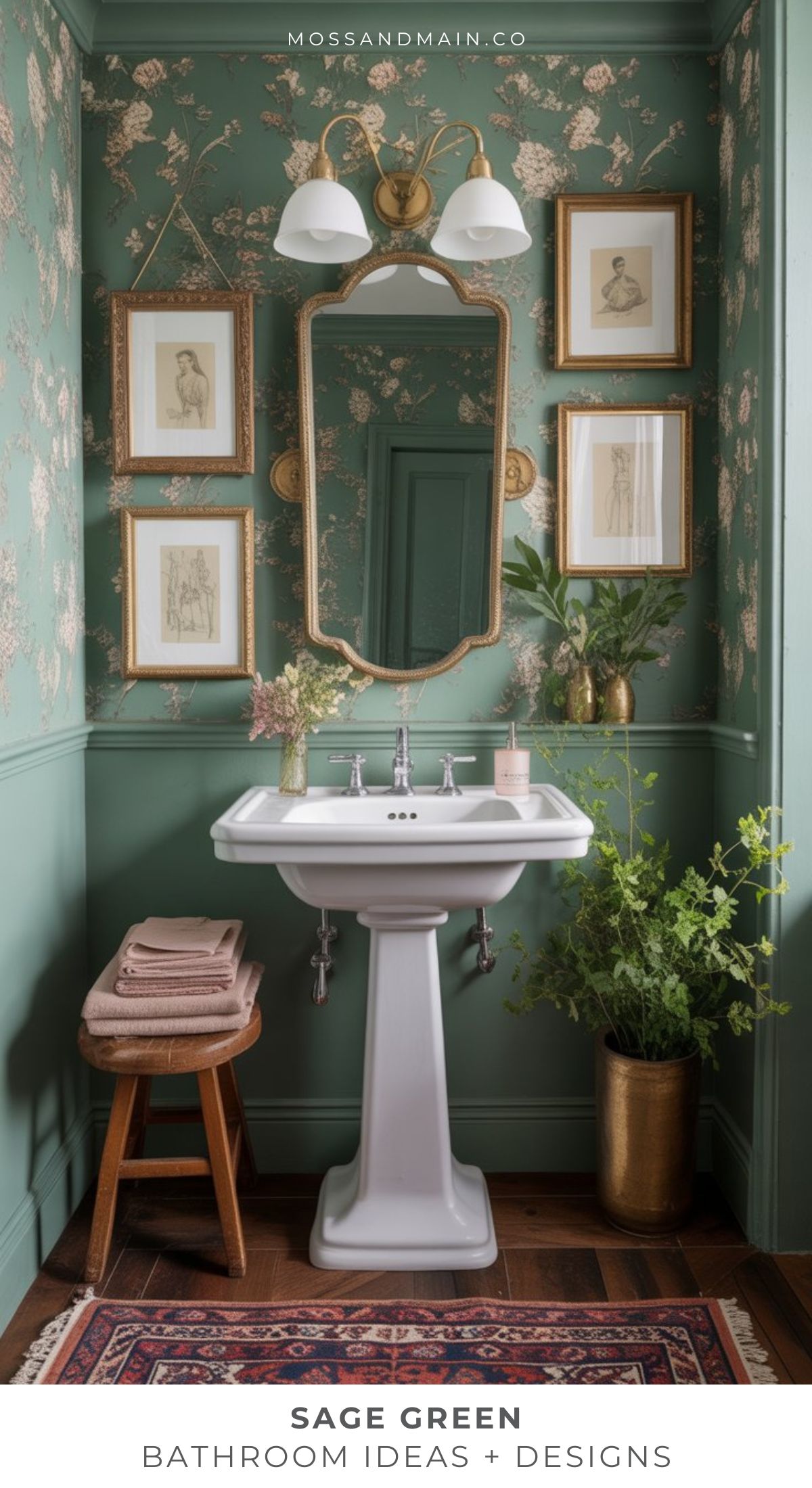 A sage green bathroom with floral wallpaper, a white pedestal sink, and gold-framed art. Stacked towels, lush plants, and a rug complete the vintage look—perfect inspiration for chic bathroom ideas.