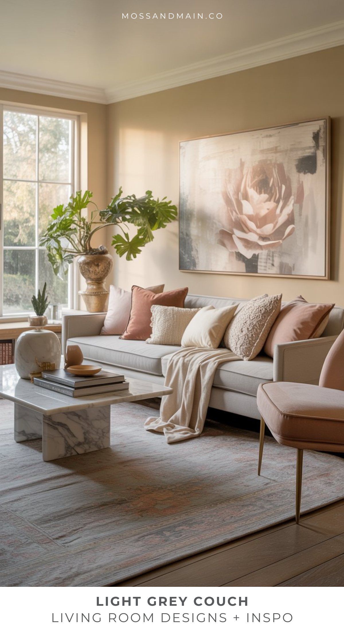 A stylish light gray couch living room with blush and beige pillows, a marble coffee table, a large floral art piece, indoor plants, and expansive windows flooding the space with natural light.