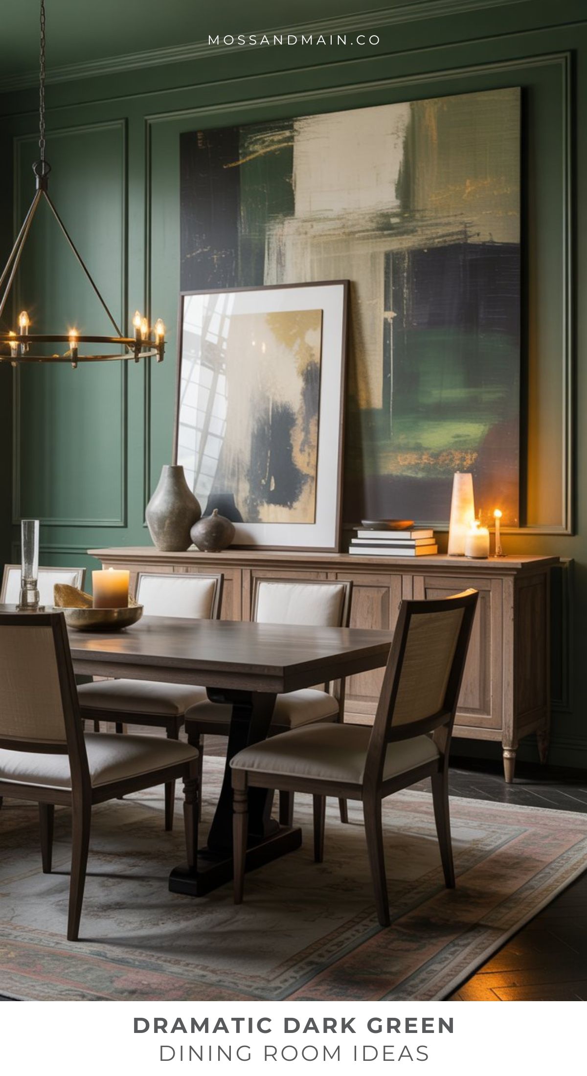 A dining room with dramatic dark forest green walls, a large abstract painting, a wooden table with beige chairs, a sideboard with vases and candles, and a modern chandelier—perfect inspiration for moody green rooms in designer catalog rooms.