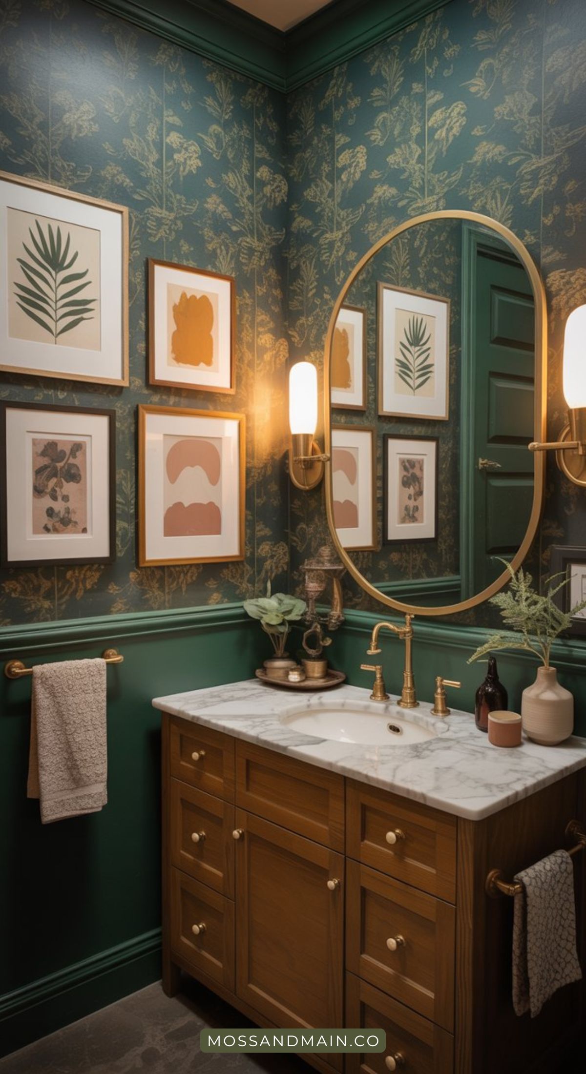 A stylish bathroom with moody dark forest green floral wallpaper, golden fixtures, a marble countertop, wooden vanity, botanical wall art, a round mirror, and soft sconce lighting. Towels hang neatly on gold bars—worthy of any designer catalog.