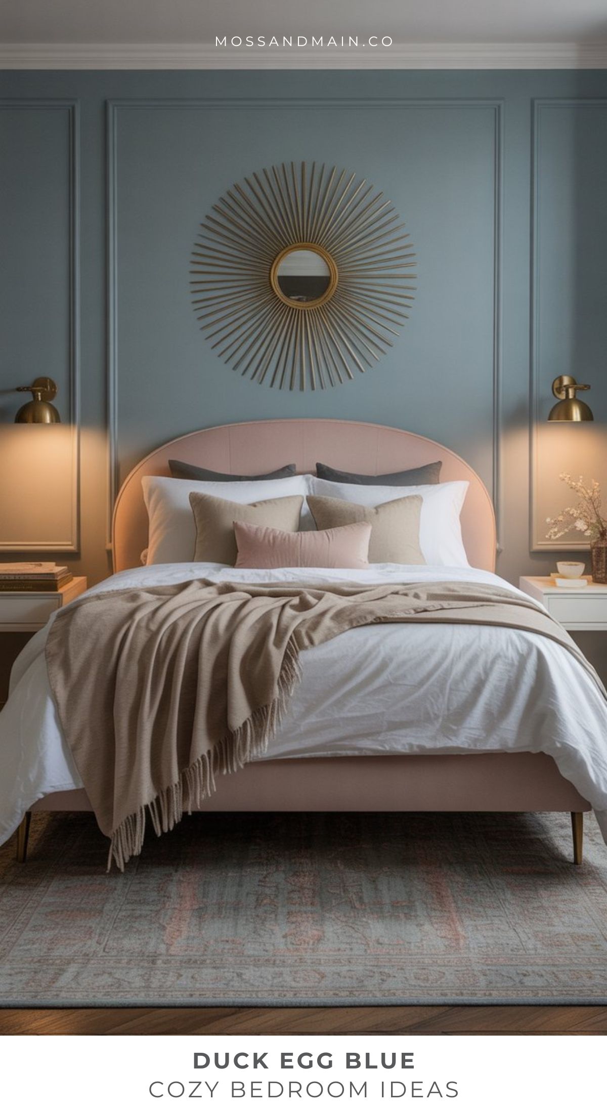 A stylish Duck Egg Blue Bedroom with an accent wall, sunburst mirror, soft pink upholstered bed, neutral bedding and throw blanket, two nightstands with lamps, and cozy decorative pillows—perfect for elegant bedroom ideas.